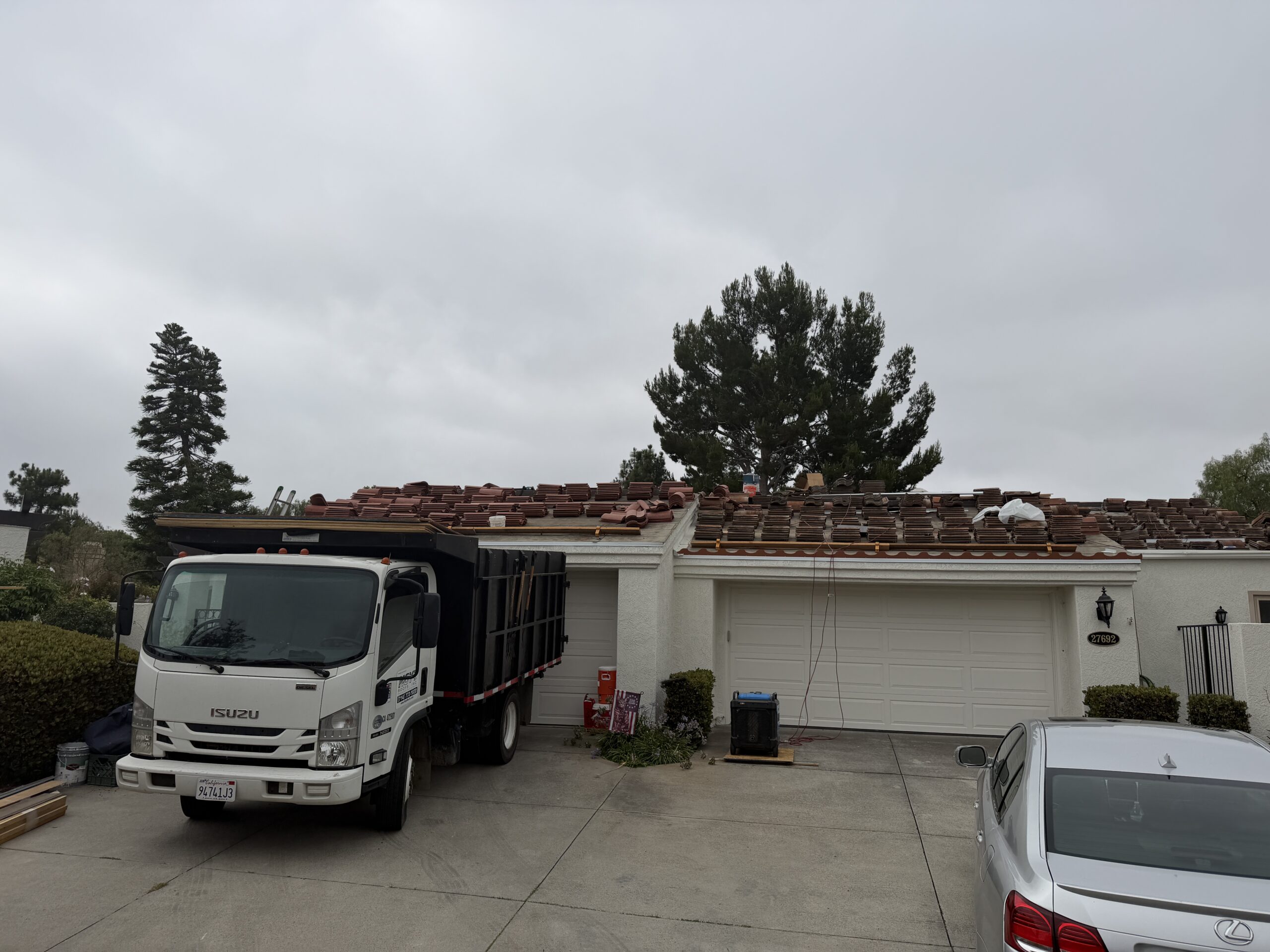 HOA tile roofing project with truck and staged materials